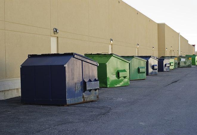 a waste management truck unloading into a construction dumpster in Aledo